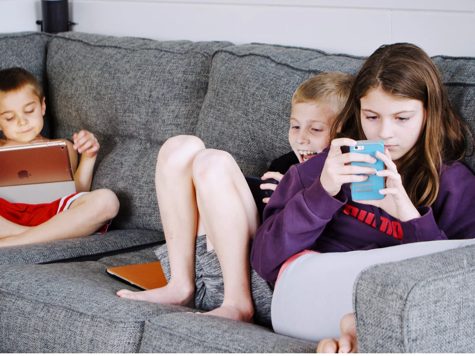 Niños utilizando móviles y tabletas en casa