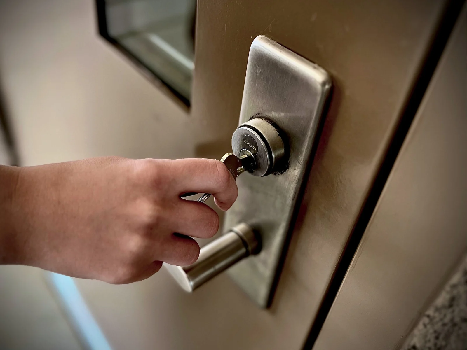 Mano abriendo con llave la cerradura de una vivienda