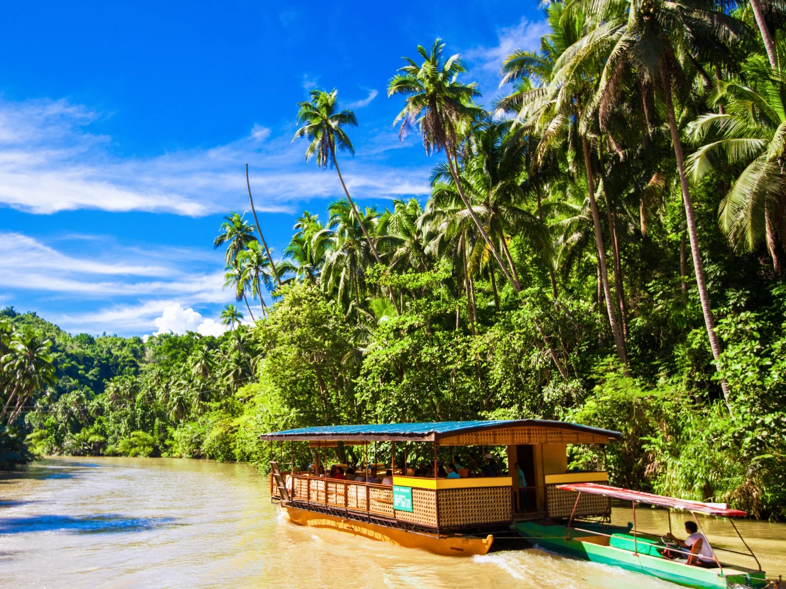Embarcación turística navegando por un río tropical durante un viaje