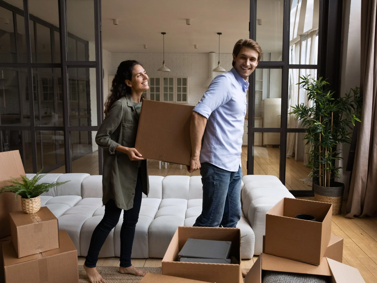 Pareja trasladando cajas en una vivienda de alquiler