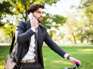 Profesional autónomo hablando por teléfono mientras se desplaza en bicicleta