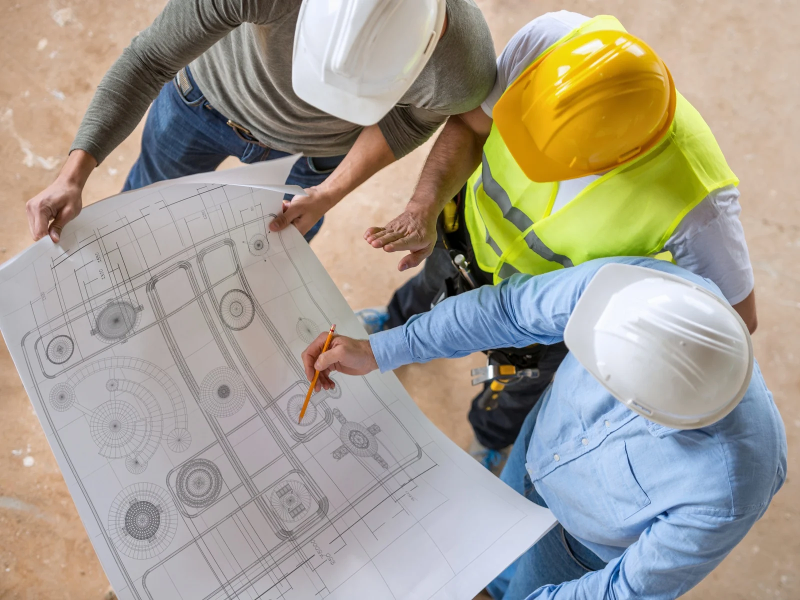 Profesionales de construcción revisando planos técnicos de una obra