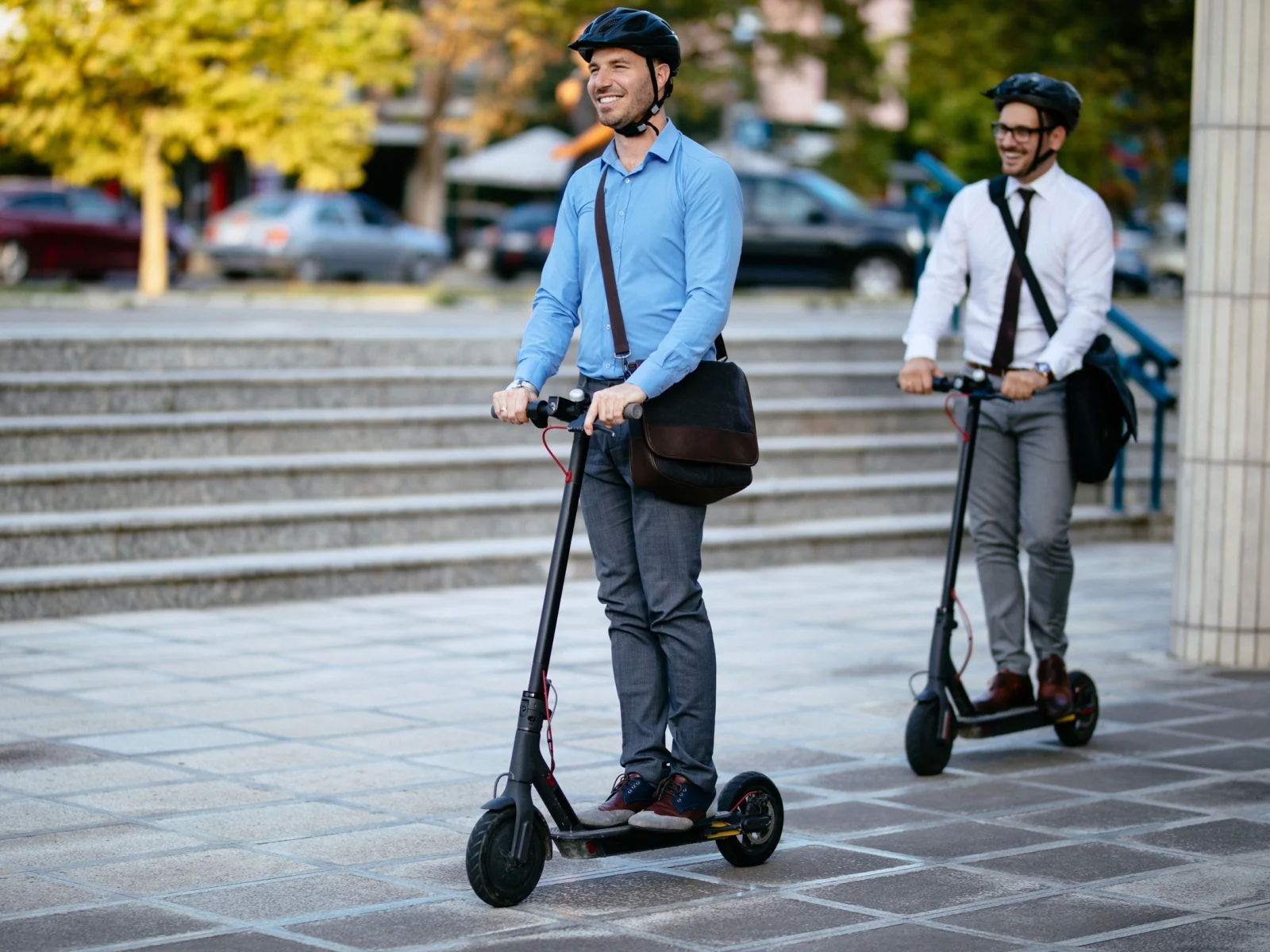 Profesionales desplazándose en patinetes eléctricos por la ciudad